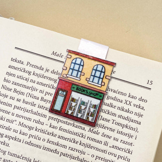 Book with a bookmark featuring a illustration of a bookshop on an open page.
