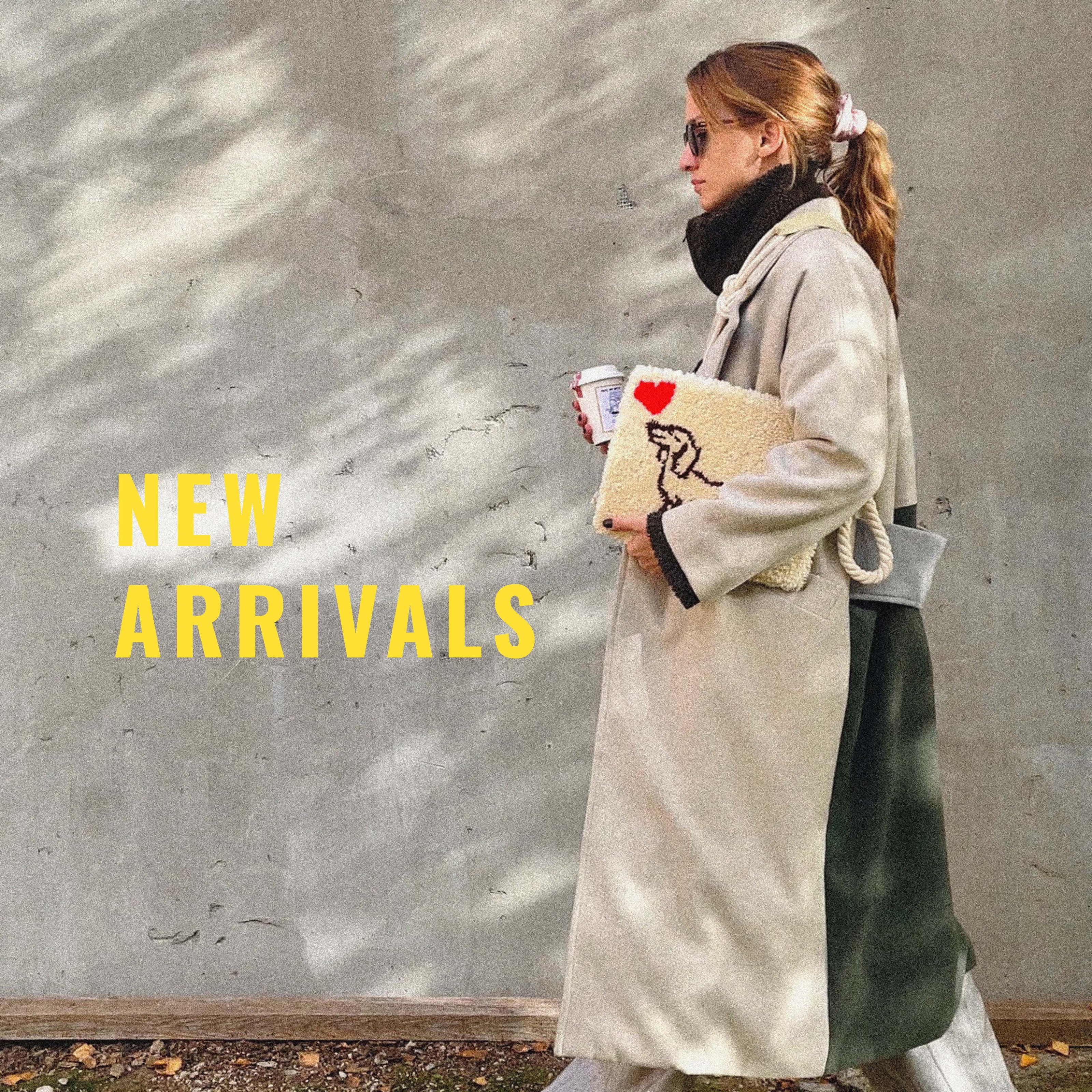 Woman holding a bag with a heart design against a textured wall, with 'NEW ARRIVALS' text.